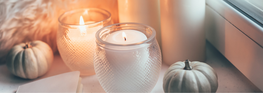 candles by a window with small green pumpkins decorating the space