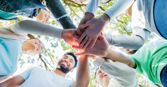 creative community people in circle with hands together