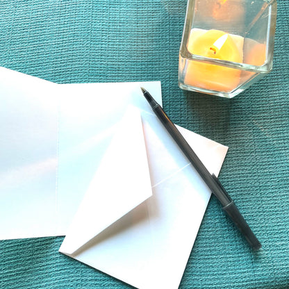 Blank‑inside autumn leaf notecard by Katie Weaver displayed with a pen and candle