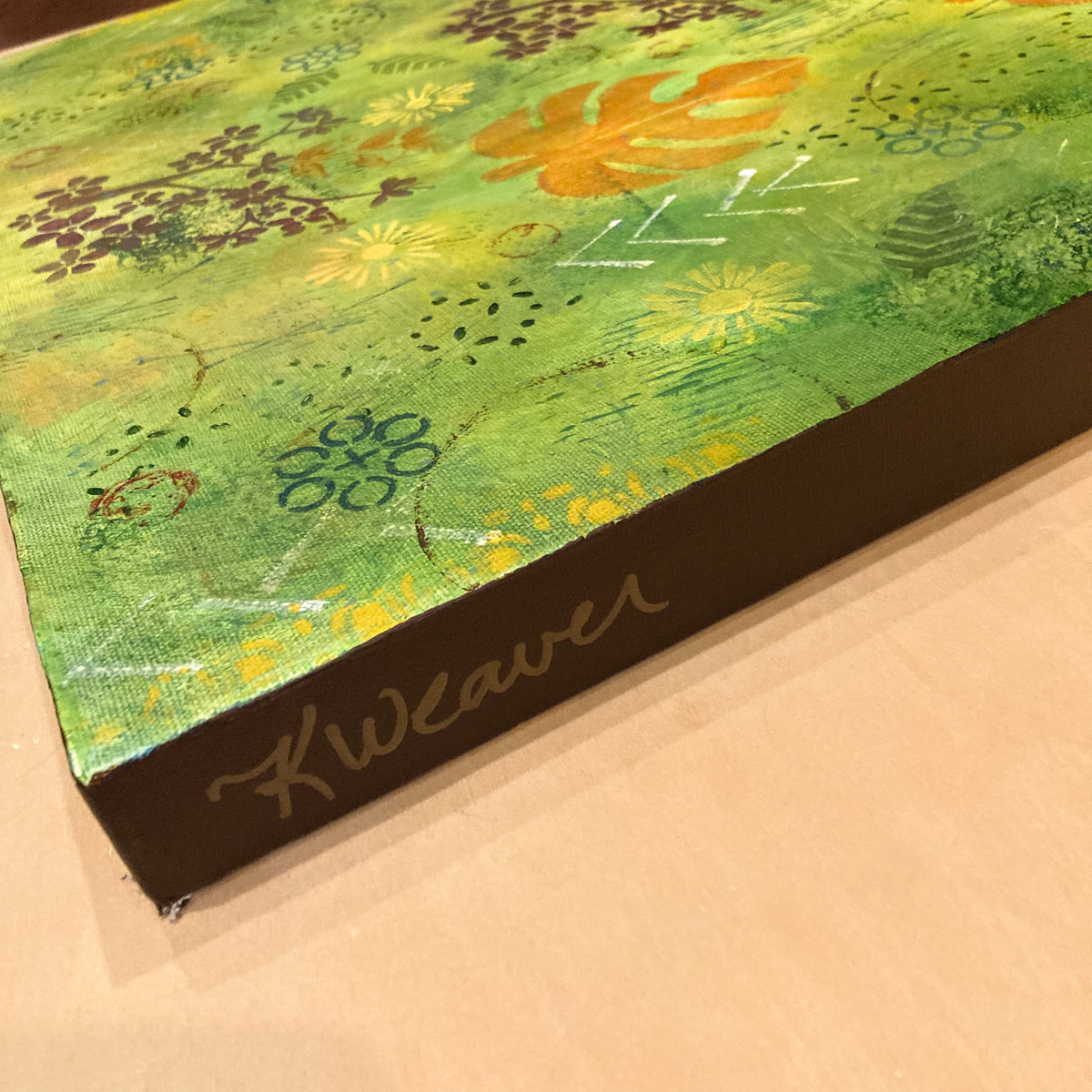 Side view of vibrant green forest‑inspired painting by Katie Weaver with vertical orange leaves