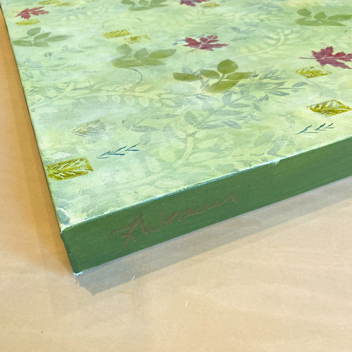 Side view detail of patterned maple leaf painting by Katie Weaver with bright green and dark red fall leaves