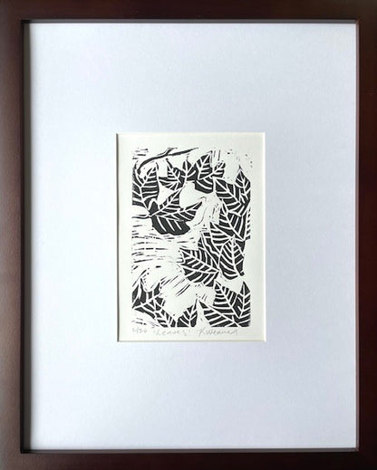 Fall leaf linocut print by Katie Weaver with winding black leaf motifs shown in a mat and frame