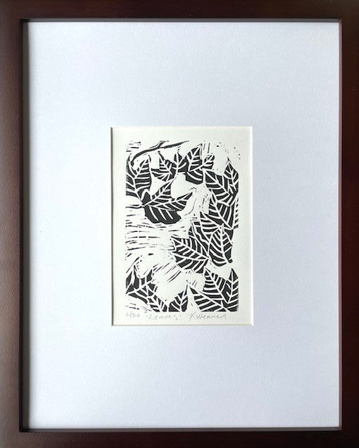 Fall leaf linocut print by Katie Weaver with winding black leaf motifs shown in a mat and frame