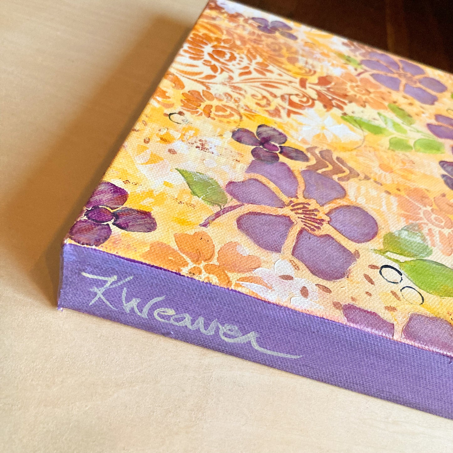 side view floral Hawaiian theme acrylic painting on canvas purple flowers orange flowers green leaves circles and scrolling shapes warm and cheerful sides painted purple