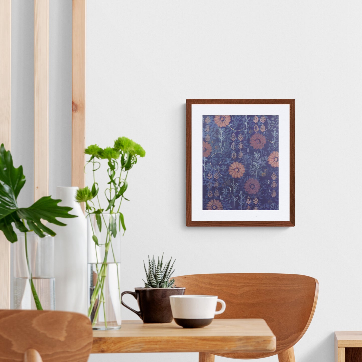 print with mahogany frame and white matte of abstract painting plum background with mauve flowers and light blue leaves vertical movement and calm feeling in room with breakfast table and plants